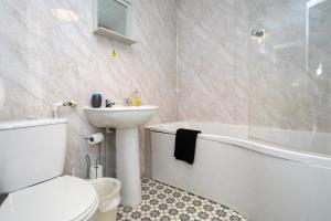 a bathroom with a sink and a toilet and a bath tub at Glenmore Lodge in Belfast +9 photos