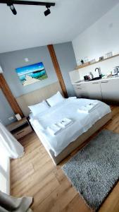 a bedroom with a large white bed and a rug at Nautica apartments&studios in Peštani