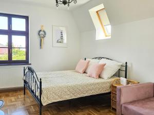 una camera da letto con un letto con cuscini rosa e bianchi di visit baltic - Dom wakacyjny Simona Ferienhaus Szkolna a Świnoujście