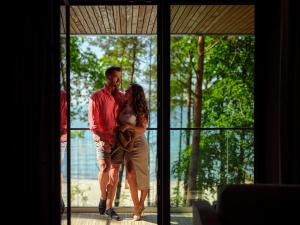 a man and a woman standing in front of a window at Baltic Jet Luxury Aparthotel in Ustronie Morskie