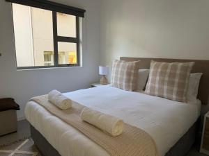 a bedroom with a large bed with two towels on it at Stylish Ballito Home - Zimbali Wedge in Ballito +25 photos