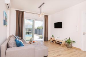 a living room with a couch and a tv at Poet Villa in Agios Georgios