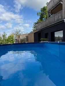 a large blue swimming pool in front of a house at Urban Studio in Buttelstedt