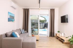 a living room with a couch and a sliding glass door at Poet Villa in Agios Georgios