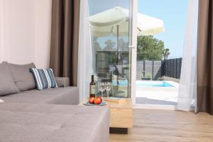 a living room with a couch and a table with wine glasses at Poet Villa in Agios Georgios +26 photos