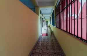 Un pasillo vacío de una escuela con ventanas y un piso. en Hotel O SPRINGVILLA, en Dispur