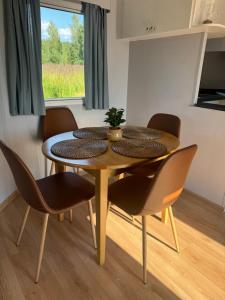 a dining room table and chairs in a room at Summer house Sunny coast in Lankstiņi