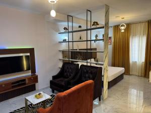 哈科特港Spacious Studio Apartment in Portharcourt的一间带床和电视的客厅