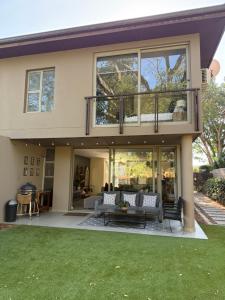 a house with a balcony with a couch and a table at Stylish Ballito Home - Zimbali Wedge in Ballito