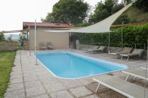 a swimming pool in a yard with a tent and chairs at Podere Quartarola in Modigliana