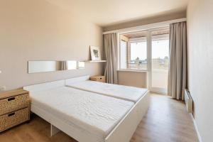 Una habitación blanca con una cama y una ventana en Clapotis A 0701 G, en Oostduinkerke 17 fotos más