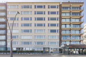 un edificio alto con una luz de la calle delante de él en Clapotis A 0701 G, en Oostduinkerke