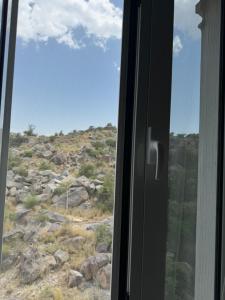 a window with a view of a rocky mountain at شقة مميزة بتصميم حديث in Baljurashi