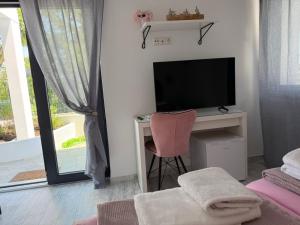 a room with a television and a desk with a chair at Wtite Sea 2 in Kavála