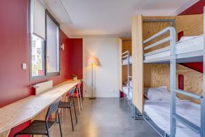 ein Zimmer mit Etagenbetten und einem Tisch und Stühlen in der Unterkunft Auberge de Jeunesse Barbey - Youth Hostel Bordeaux in Bordeaux