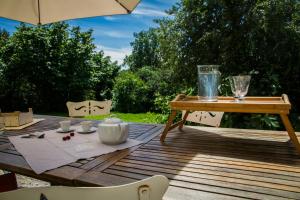 Una mesa de madera con un juego de té sobre una terraza de madera. en Restored 18Th Century Farmhouse Near Albi, en Rouffiac 12 fotos más