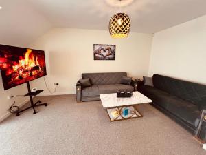 a living room with a couch and a flat screen tv at Middlesbrough Spacious Flat 2 bedrooms & 2 bathrooms & Free Private Parking & Wifi in Middlesbrough