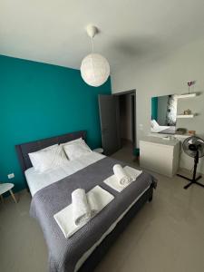 a bedroom with a large bed with a blue wall at Mountain & Sea Escape in Leptokaria