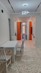 a dining room with a white table and chairs at Elit in Bishkek