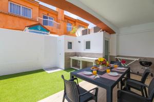 patio ze stołem i krzesłami oraz budynek w obiekcie Casa Esther Corralejo w Corralejo