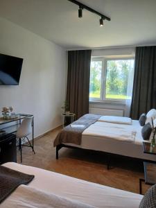 a hotel room with two beds and a window at Hotel Fuchs & Hase SELF CHECK IN in Rosegg