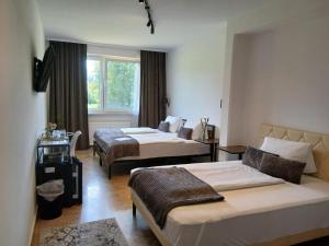 a hotel room with two beds and a window at Hotel Fuchs & Hase SELF CHECK IN in Rosegg