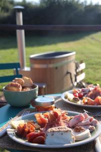 ein Tisch mit zwei Tellern Essen darauf in der Unterkunft Cabane luxe & spa extérieur Les Magnolias in Barjou