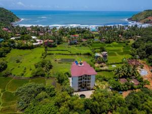 an aerial view of a house with the ocean at The Hosteller Gokarna in Gokarna