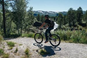 a man riding a bike on a dirt road at Lisletun in Hovden