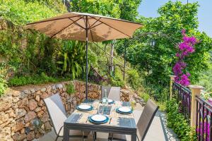 a table with an umbrella on a patio at Dimora Concept -Ca' Lena - SeaView Terrace and Parking in Borgio Verezzi