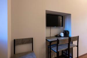 a room with a desk with a television and a chair at New Roman Experience in Rome