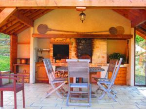 a patio with chairs and a table and a kitchen at Les Chalets de Jade in Viremont