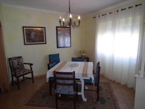Un comedor con una mesa y sillas y una lámpara de araña. en West Terrace House - Ocean View, en Lourinhã