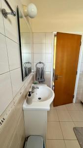 a bathroom with a white sink and a brown door at Villa Porta Aurea in Ayia Napa