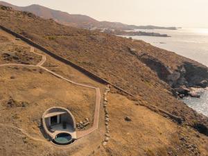a boat on the side of a hill next to the ocean at Olen Syros in Megas Yialos-Nites