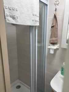 a shower with a glass door in a bathroom at Knight & Sunshine Luxury Flatlet in Kleinbaai