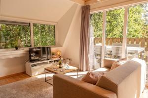 a living room with a couch and a television at Hidden jewel in Durbuy's forest in Durbuy