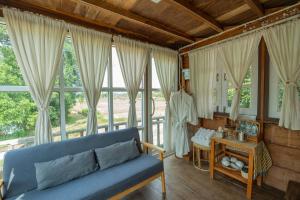 a living room with a blue couch and windows at ต้งโฮมสเตย์ กลางทุ่งนา Local Homestay and View in Nan