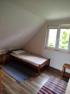 a bed in a room with a window at Spokojna 10 Dom Wakacyjny w Ogrodzie in Polańczyk