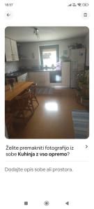 a kitchen with a table and a kitchen with a refrigerator at Lovely 1- bedroom apartment in Skofja Loka in Škofja Loka