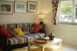 una sala de estar con un sofá con un perro. en Casa Oleandros, en Lourinhã