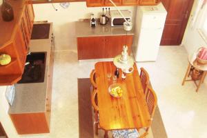 Una vista aérea de una cocina con una mesa y sillas de madera. en Casa Oleandros, en Lourinhã 33 fotos más