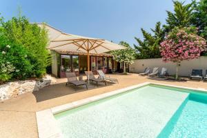 a swimming pool with chairs and an umbrella at Bergeries Saumane, Petite Bergerie in Saumane-de-Vaucluse