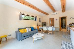 a living room with a blue couch and a table at Bergeries Saumane, Petite Bergerie in Saumane-de-Vaucluse
