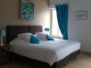 a bedroom with a bed with blue pillows and a window at Chateau Pech-Céleyran in Salles-dʼAude