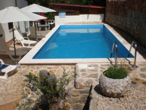 a swimming pool in the middle of a yard at Apartments Seka in Risika