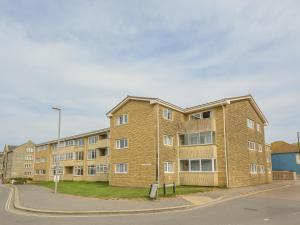 Un edificio de apartamentos de ladrillo al costado de una calle. en Beachcombers, 13 Chesil House, en Bridport