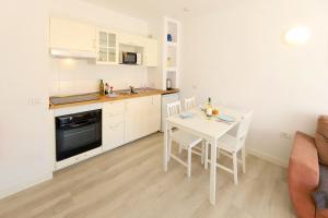 卡门港塞尔玛立娜别墅酒店的厨房兼餐厅，配有桌椅