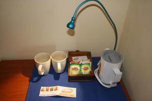 une table avec deux tasses et une lampe dessus dans l'établissement Affittacamere La Branda, à La Spezia