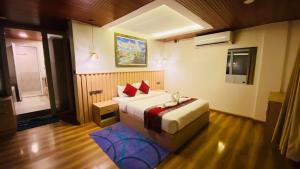 una habitación de hotel con una cama y un televisor en Himalayan Sunrise, en Dhulikhel